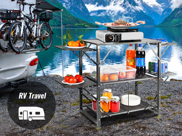 camper by a lake with a VEVOR camping kitchen table, stocked with food and drinks, bicycles mounted.