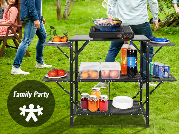 family gathering with VEVOR camping kitchen table, bbq grill, and organized shelves on a lawn.