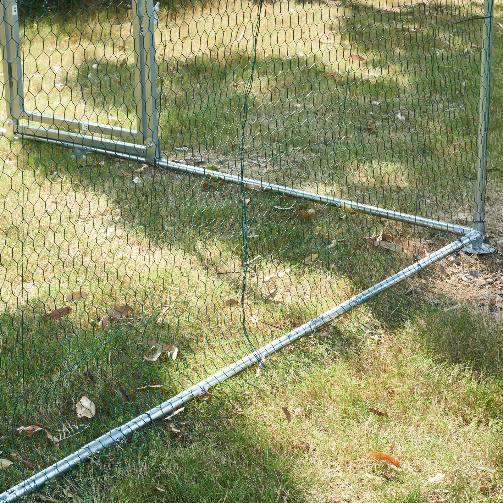 VEVOR chicken coop metal frame with green mesh on grassy outdoor area.