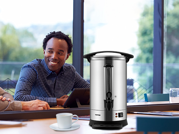 VEVOR coffee urn on a meeting table with people, a cup of coffee, and spilled coffee beans nearby.