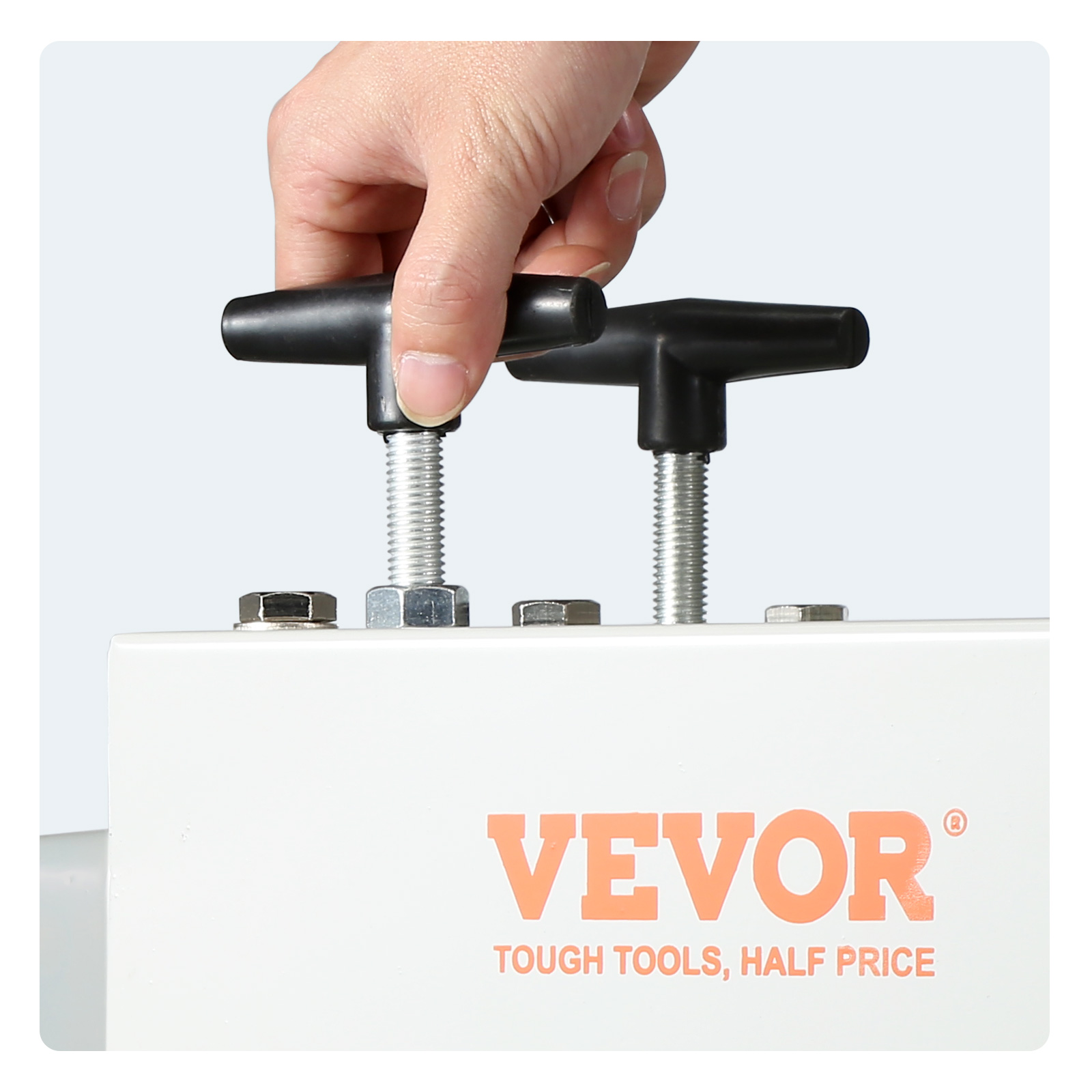 hand adjusting bolts on a VEVOR wire stripping machine with company logo and slogan visible.