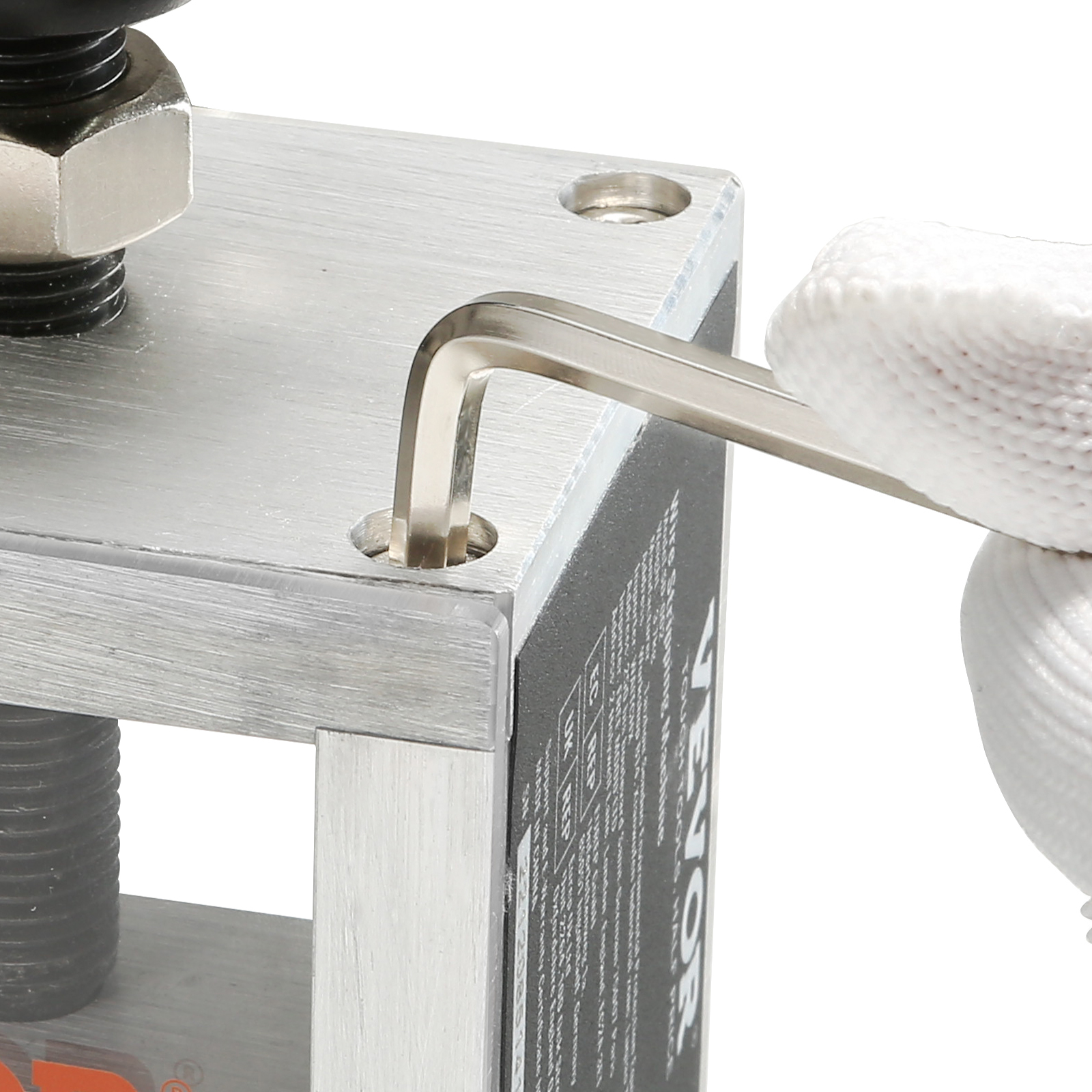 adjusting screws on the VEVOR wire stripping machine with an allen wrench while wearing white gloves.
