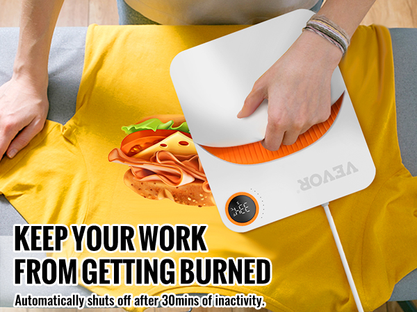 asmuo, naudojantis VEVOR šilumos spaudos mašina ant geltonos spalvos marškinėliai su sumuštinį, grafikos, apsuptas sulankstyti drabužius.