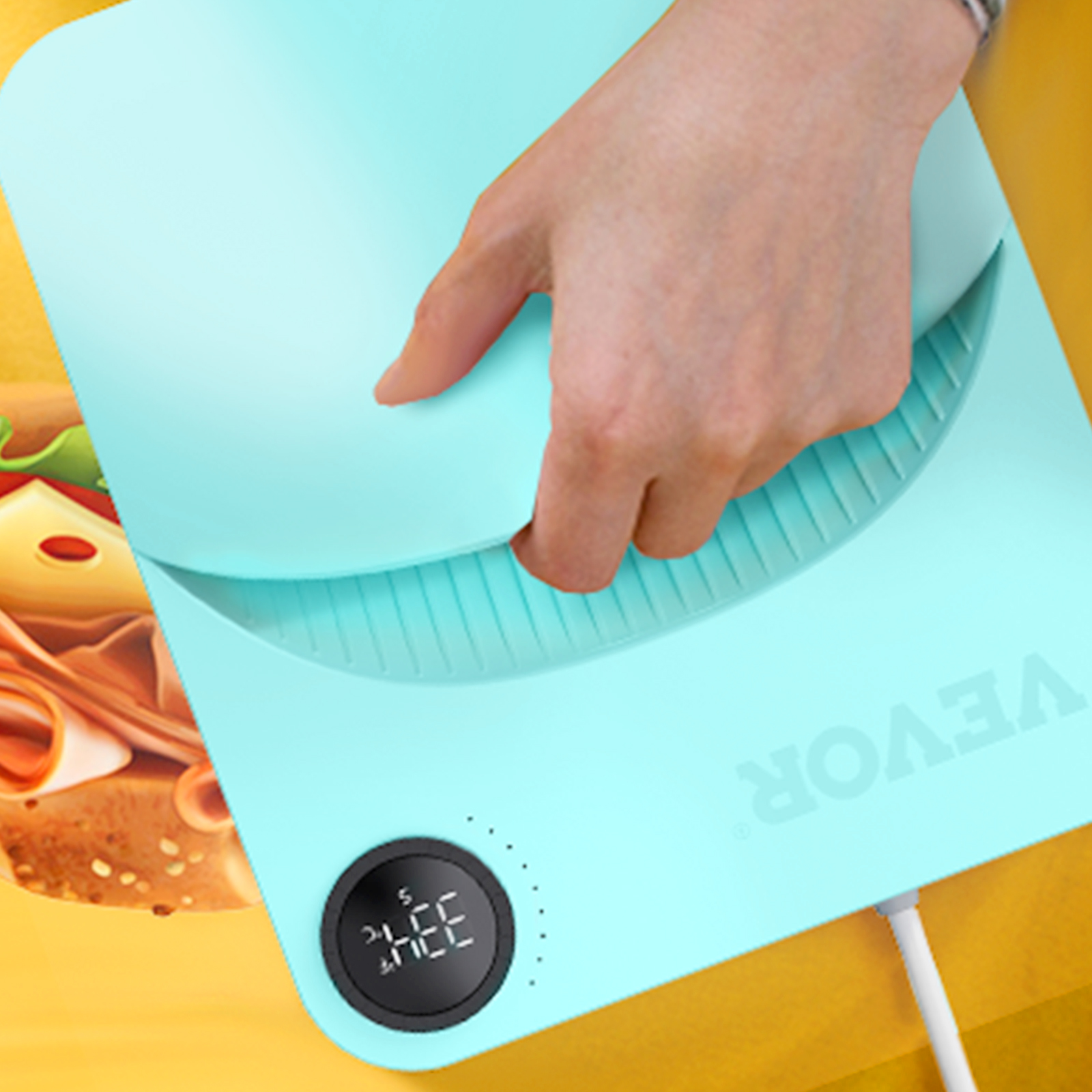 hand adjusting the VEVOR heat press machine, digital display active, on a colorful surface.