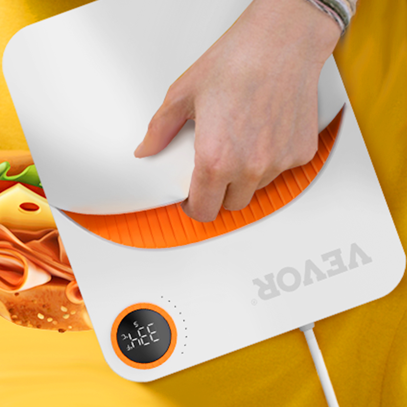 hand using the VEVOR heat press machine on a yellow fabric with a printed sandwich design.