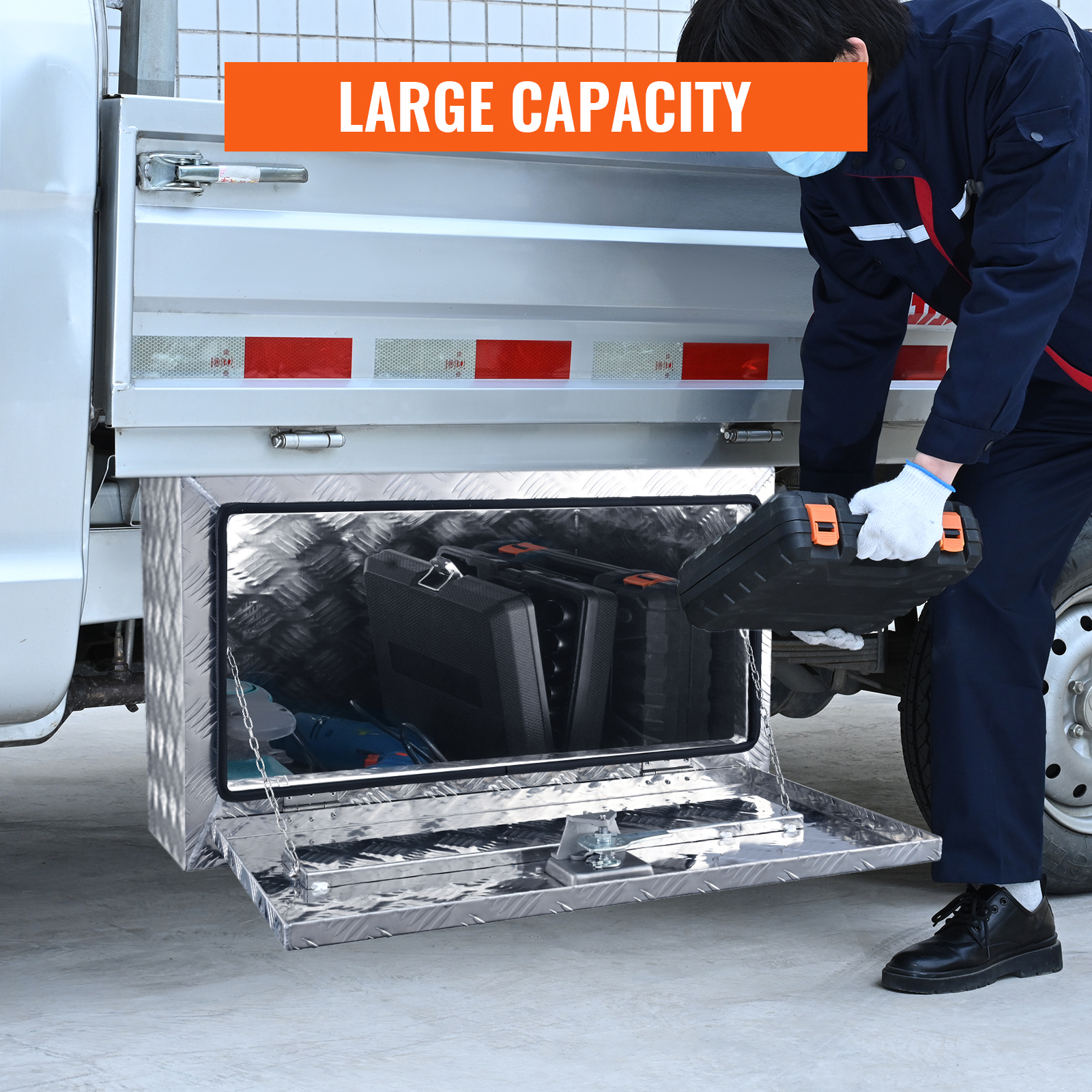 worker using VEVOR underbody truck box for tool storage, showcasing its large capacity.