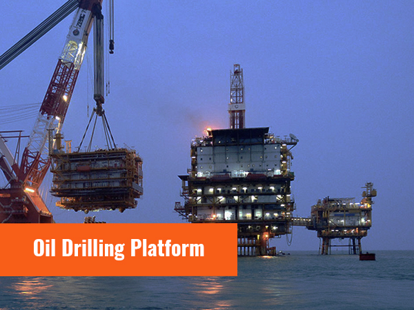 нефтяная буровая платформа в море с кранами и оборудованием, освещенными в сумерках.