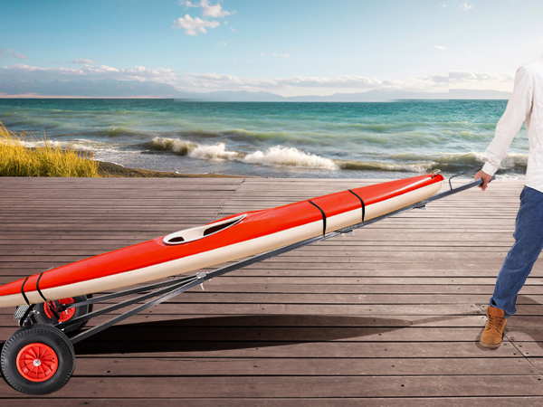 person pulling a kayak with a VEVOR boat trailer dolly on a wooden dock by the sea.