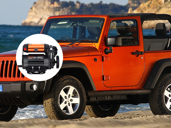orange jeep by the beach with VEVOR onboard air compressor kit; mountains and ocean background
