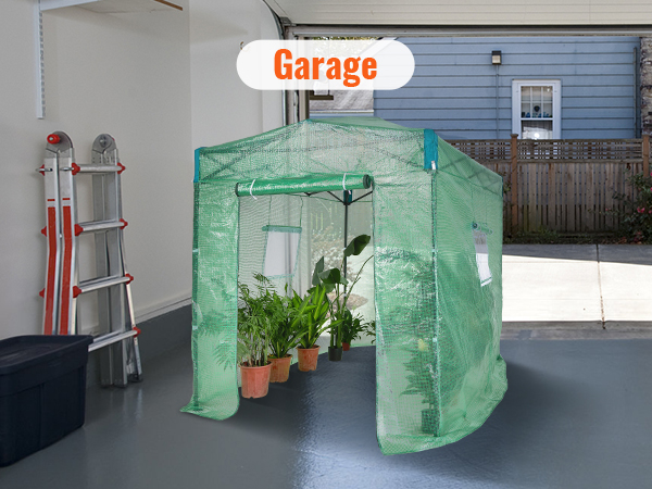 VEVOR pop up greenhouse in bright garage with growing potted plants and folded ladders nearby.