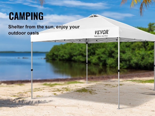VEVOR saliekamā telts ar nojumi smilšainā pludmalē ar palmām un mierīgu ezeru fonā.