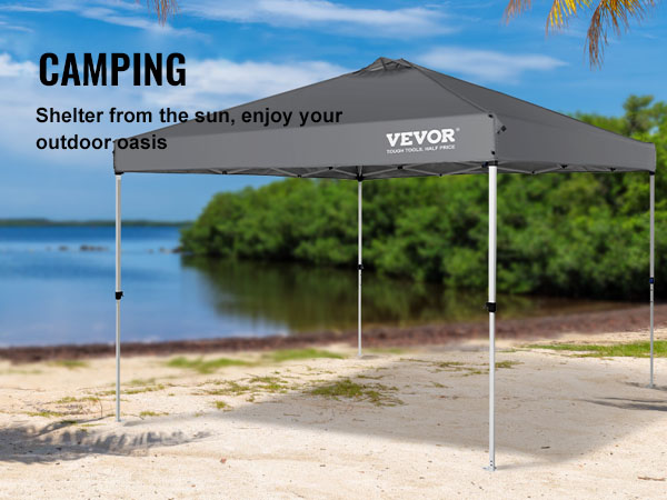 VEVOR saliekamā nojumes telts pludmalē, ko ieskauj palmas, nodrošinot saules aizsardzību kempingam.