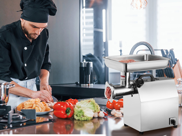 cook preparing vegetables and meat beside a VEVOR electric meat grinder in a modern kitchen.