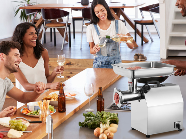 people enjoying a meal around a table with snacks, drinks, and a VEVOR electric meat grinder in a kitchen.