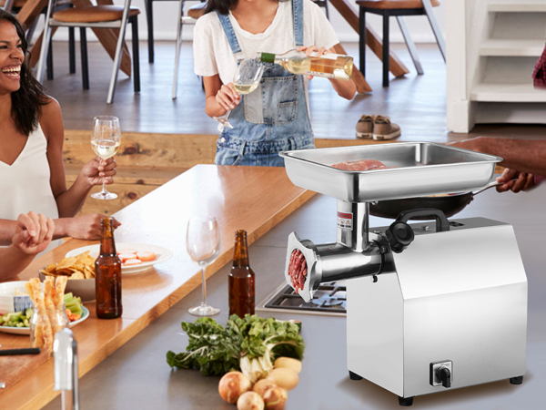 group enjoying a meal around a table with a VEVOR electric meat grinder and fresh ingredients.