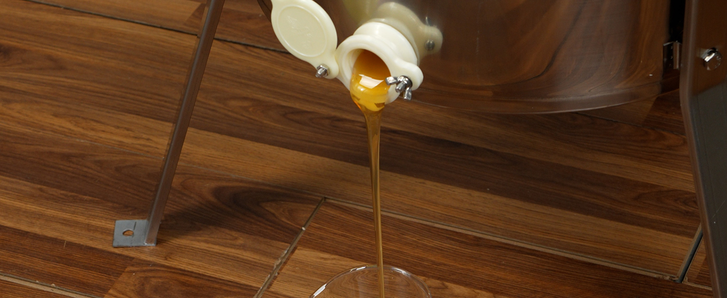 honey flowing from a VEVOR honey extractor into a glass jar on a wooden surface.