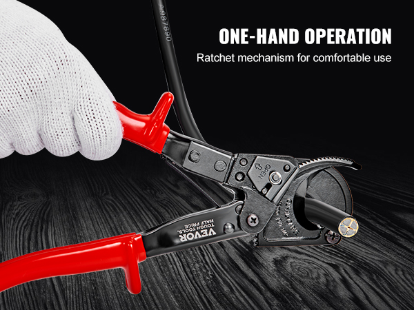 gloved hand using a VEVOR ratcheting cable cutter with red handles on a black wood surface.