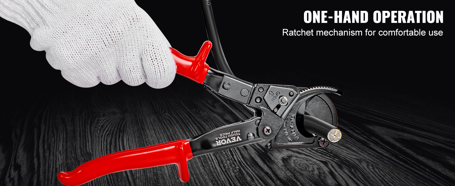 gloved hand using a VEVOR ratcheting cable cutter with red handles on a black wood surface.