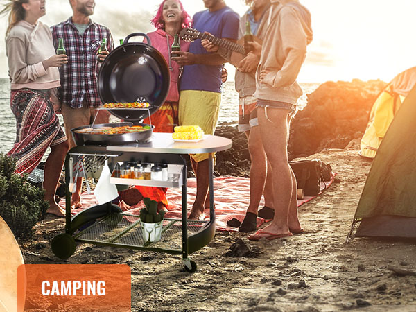 group camping with a VEVOR charcoal grill by the beach, surfboard, tent, and sunset in the background.
