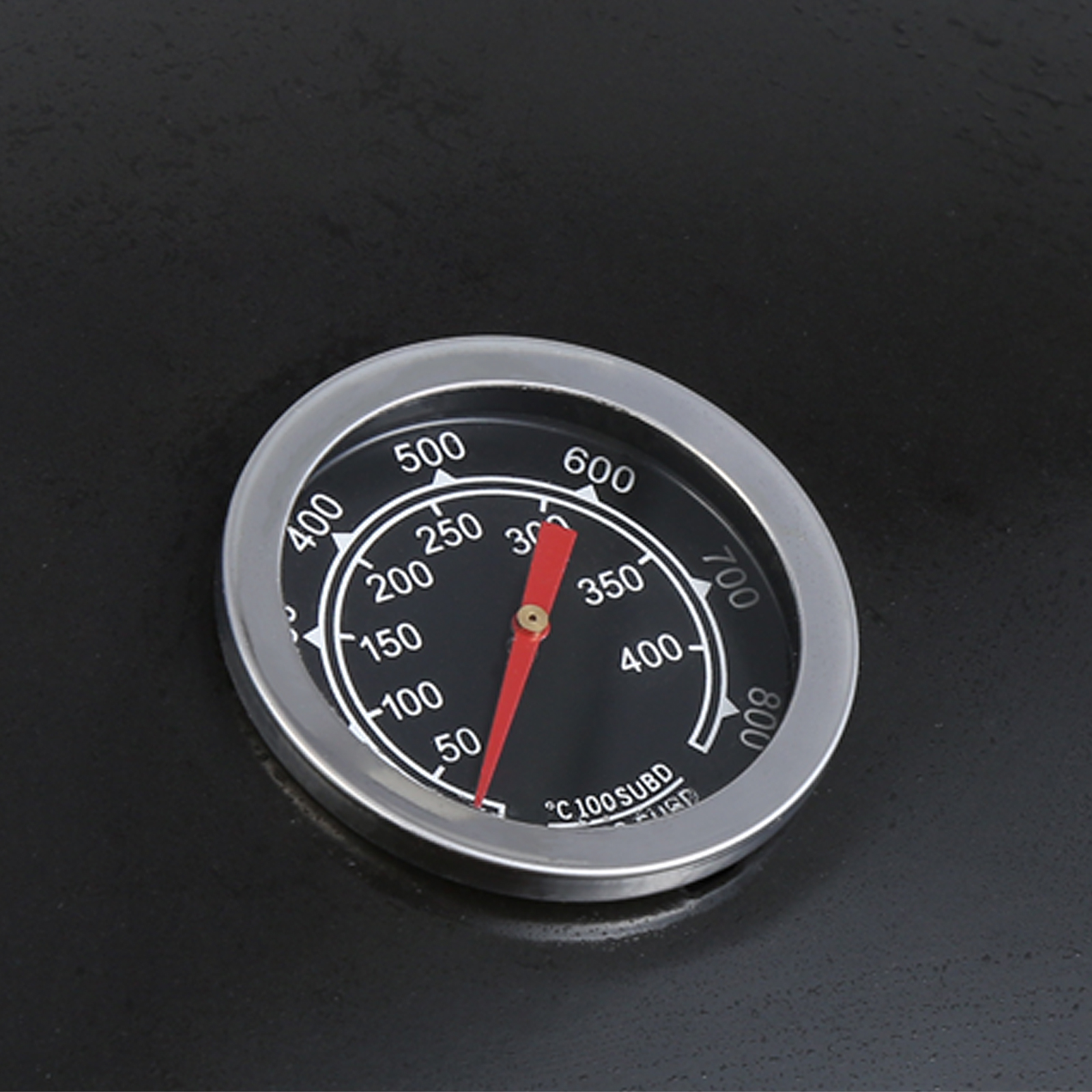 thermometer gauge on VEVOR charcoal grill displaying temperature with red needle on black background.