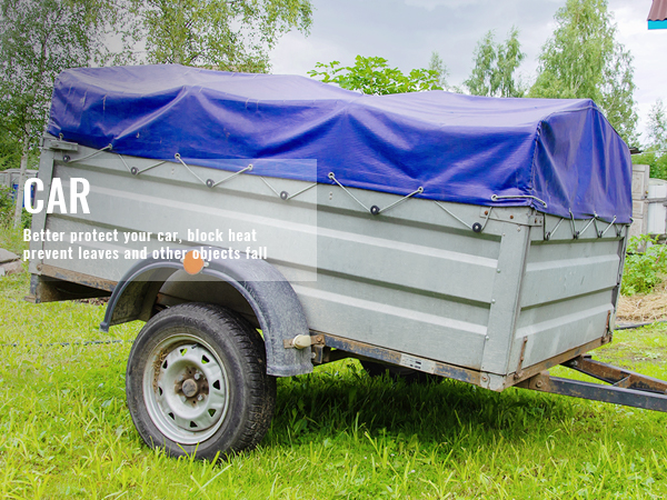 trailer covered with VEVOR waterproof tarp on grassy yard with trees in the background.