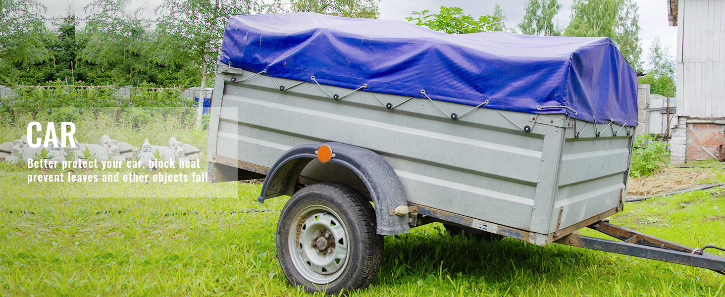 trailer covered with VEVOR waterproof tarp on grassy yard with trees in the background.