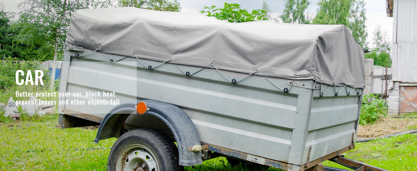 trailer with gray VEVOR waterproof tarp in a grassy area, protecting against weather elements.
