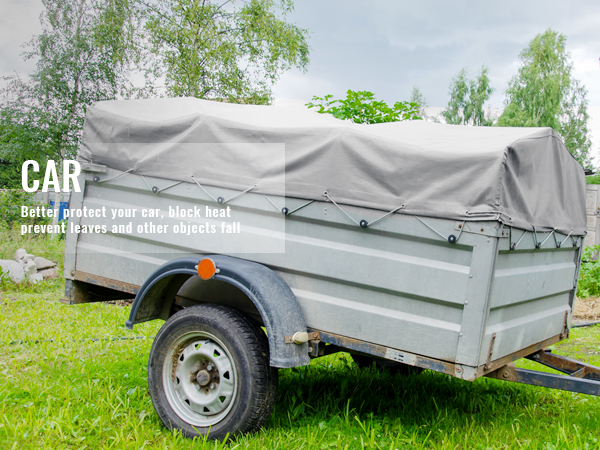trailer covered with a VEVOR waterproof tarp in a rural backyard setting for protection.