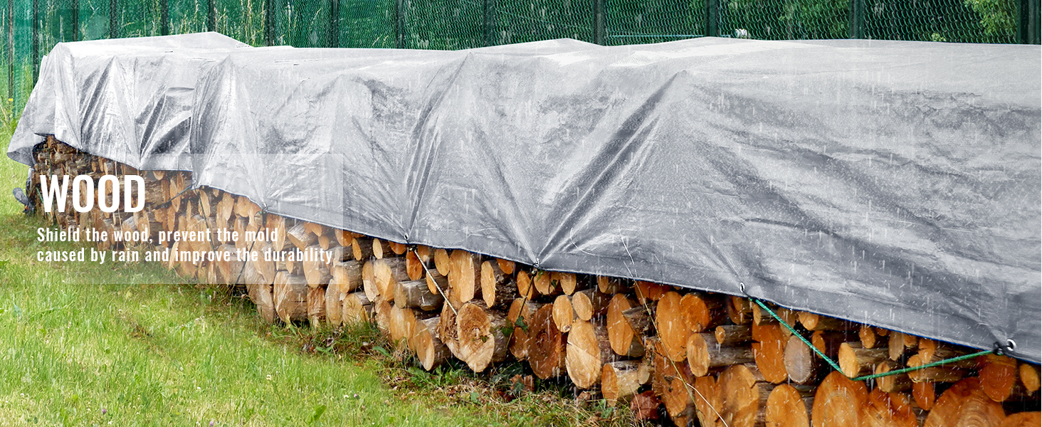 stacked firewood covered by a VEVOR waterproof tarp protecting it from rain in a grassy area.