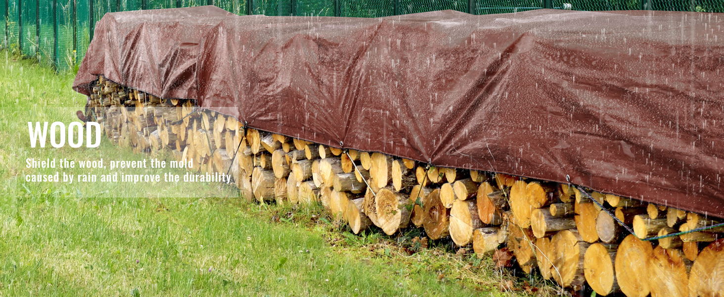 VEVOR waterproof tarp covering stacked wood, protecting it from rain beneath a vivid green fence.