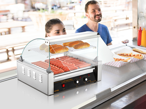 VEVOR hotdogu rullis ēdienu stendā ar hotdogiem, maizītēm un pārdevēju priekšautā, kas pieņem pasūtījumus.