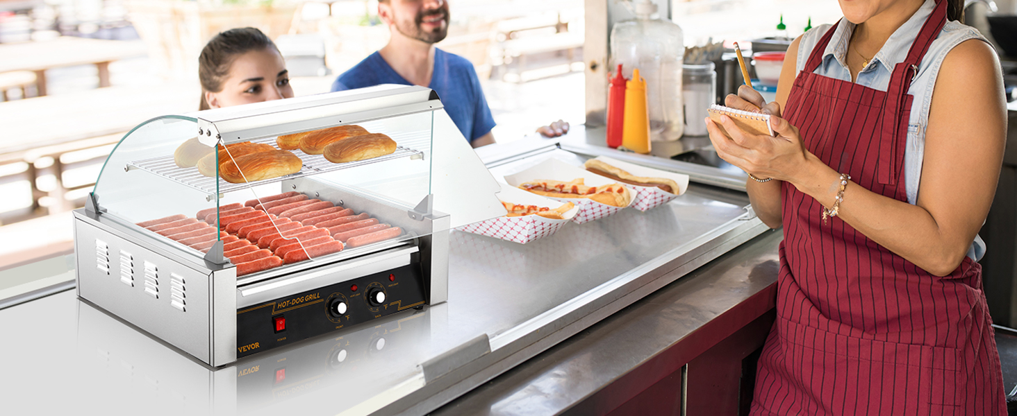 VEVOR hotdogu rullis ēdienu stendā ar hotdogiem, maizītēm un pārdevēju priekšautā, kas pieņem pasūtījumus.