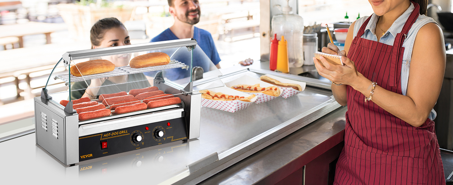 hot dogs and buns on VEVOR hot dog roller in a food stall, with vendor taking orders and condiments nearby.
