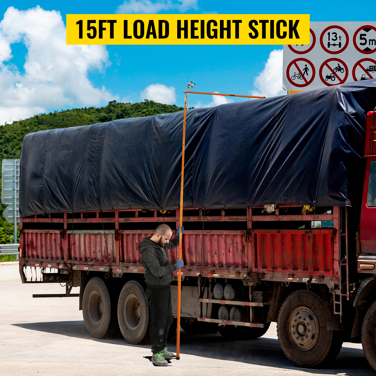 VEVOR truck height measuring stick being used next to a covered truck with safety signs in the background.