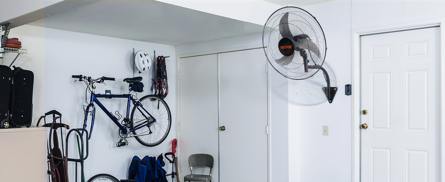 гараж с настенным вентилятором VEVOR, велосипедами, металлическим стулом и ящиками для хранения вещей у белой стены.