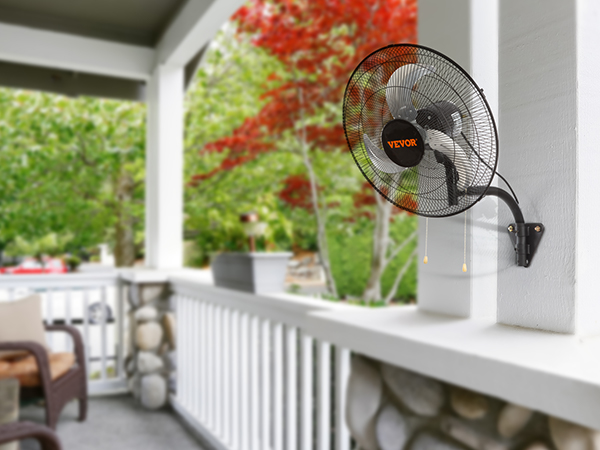 Настенный вентилятор VEVOR с функцией управления установлен во внутреннем дворике, окруженном зеленой и красной листвой.