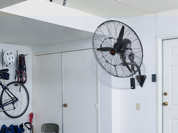 VEVOR wall-mount misting fan in a garage, with a bicycle and equipment hung on the wall.