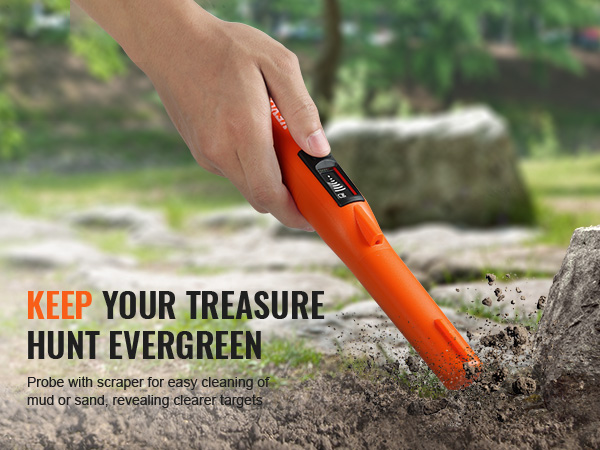 hand using VEVOR metal detector pinpointer on rocky ground in a forested area with rocks and greenery.