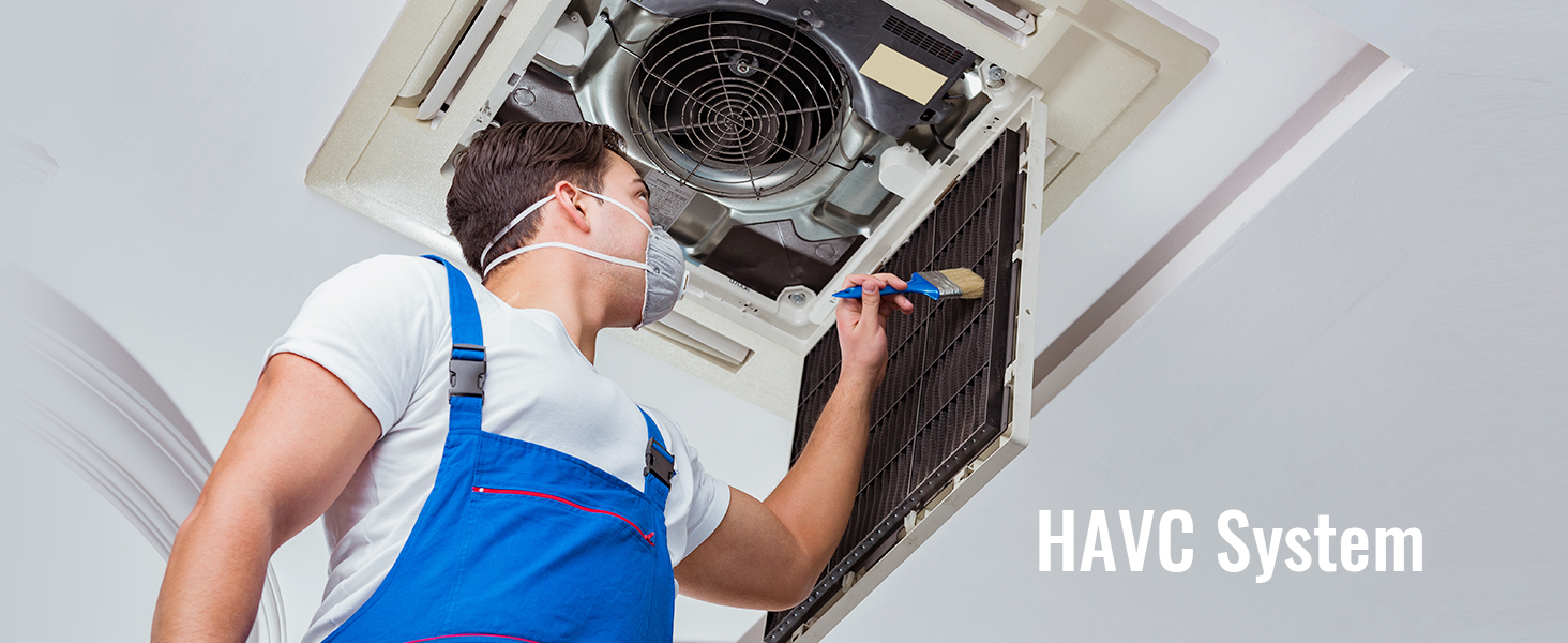 Tehniķis zilā kombinezonā tīra HVAC sistēmas filtru ar otu apkopes vajadzībām.