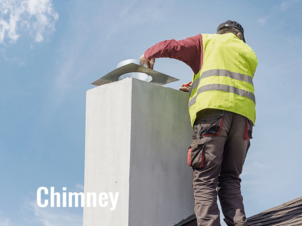 worker cleaning rooftop chimney against blue sky.