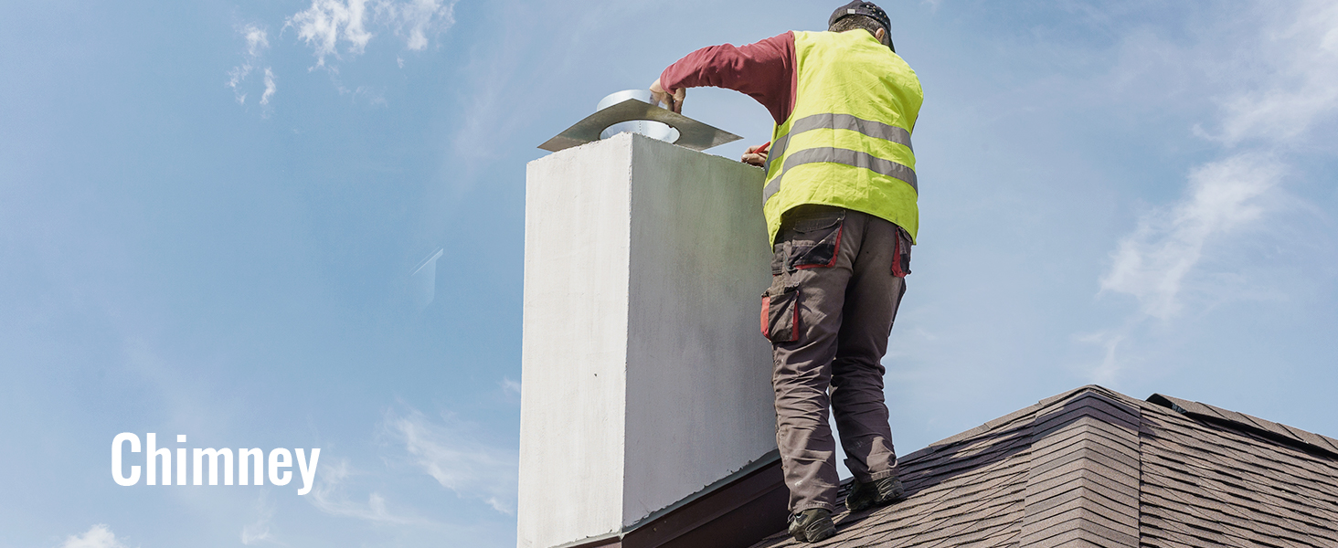 worker cleaning rooftop chimney against blue sky.
