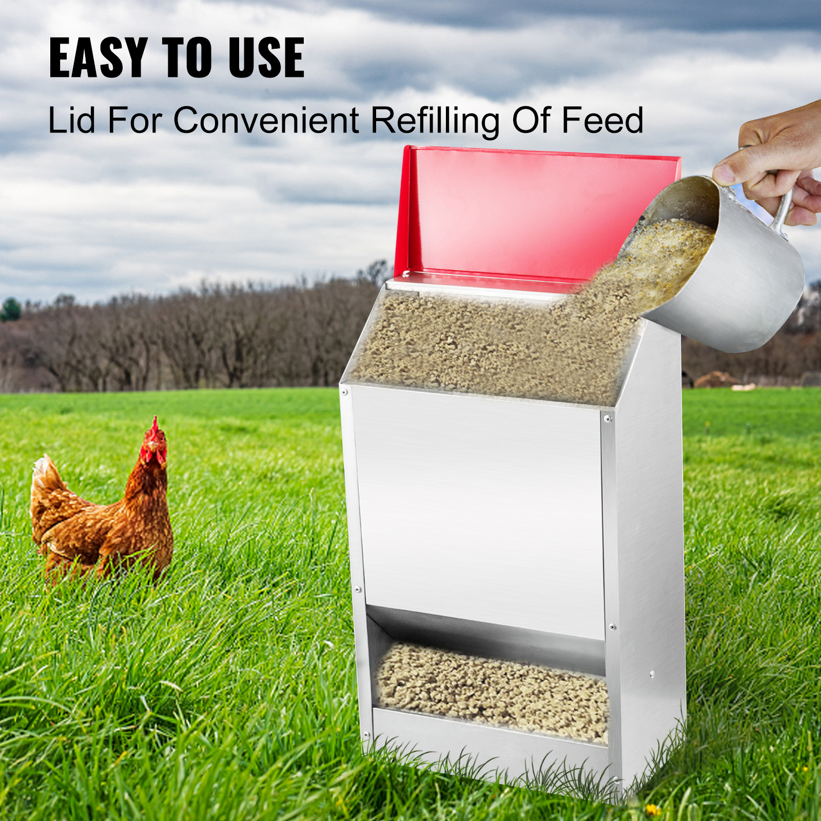 VEVOR galvanized poultry feeder with lid being refilled, chicken in grassy field.