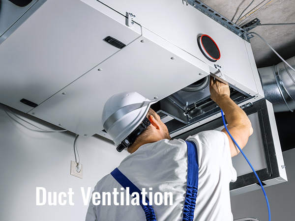 tehnik kallal kanali ventilatsioonisüsteem lähedal, laes metallist torud ja valge kast üksus.