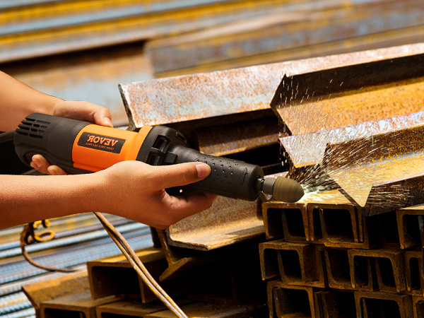 hands using VEVOR die grinder on a stack of rusted metal beams, with sparks flying.