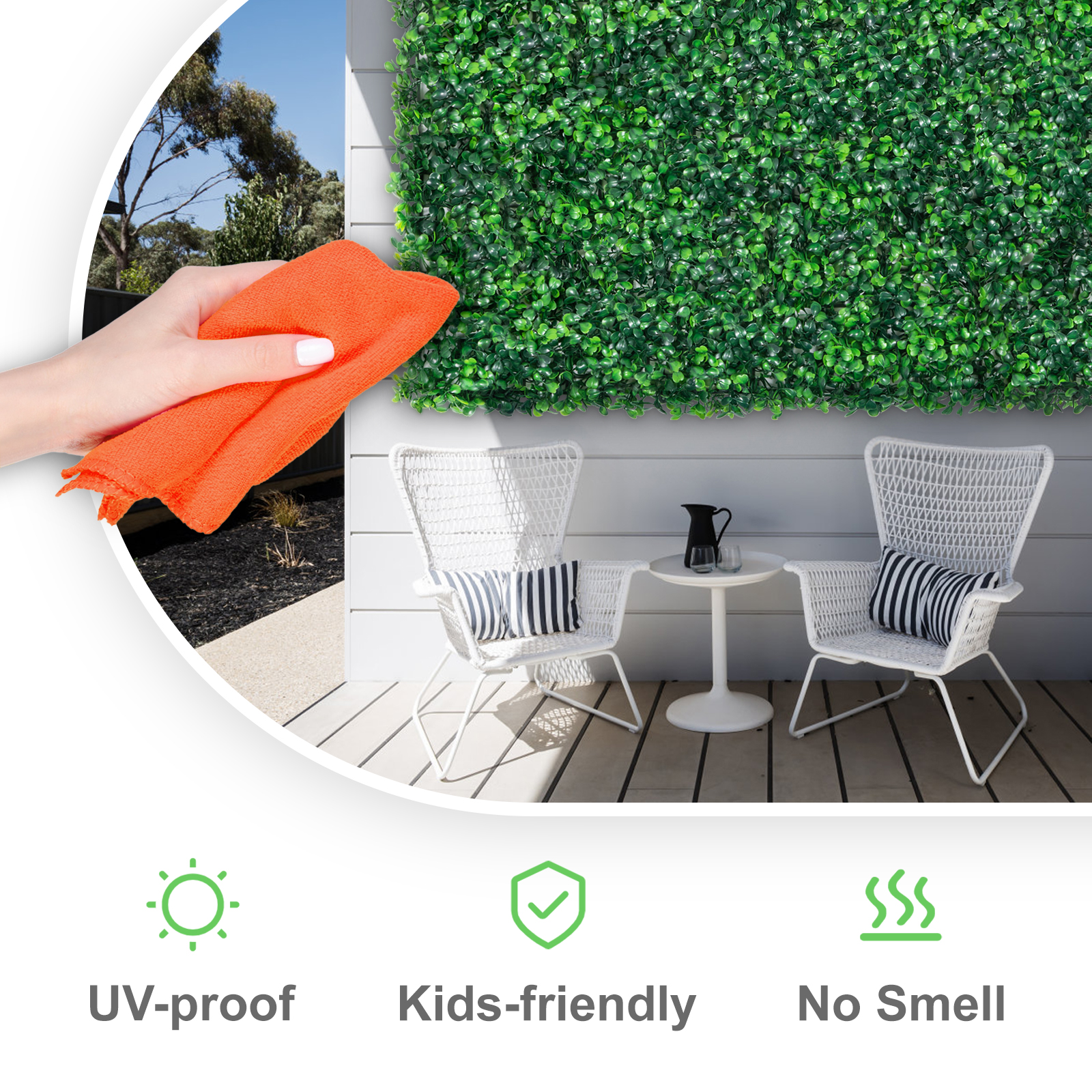 hand wiping VEVOR artificial boxwood panels on a patio with white chairs and a table.