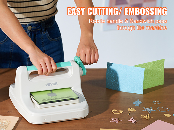 hands using VEVOR die cutting machine on table with greeting cards and cut-out designs.