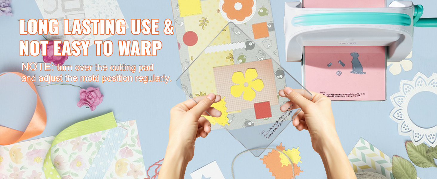 hands holding cutting pad with yellow floral die-cut next to VEVOR die cutting machine, craft supplies nearby.