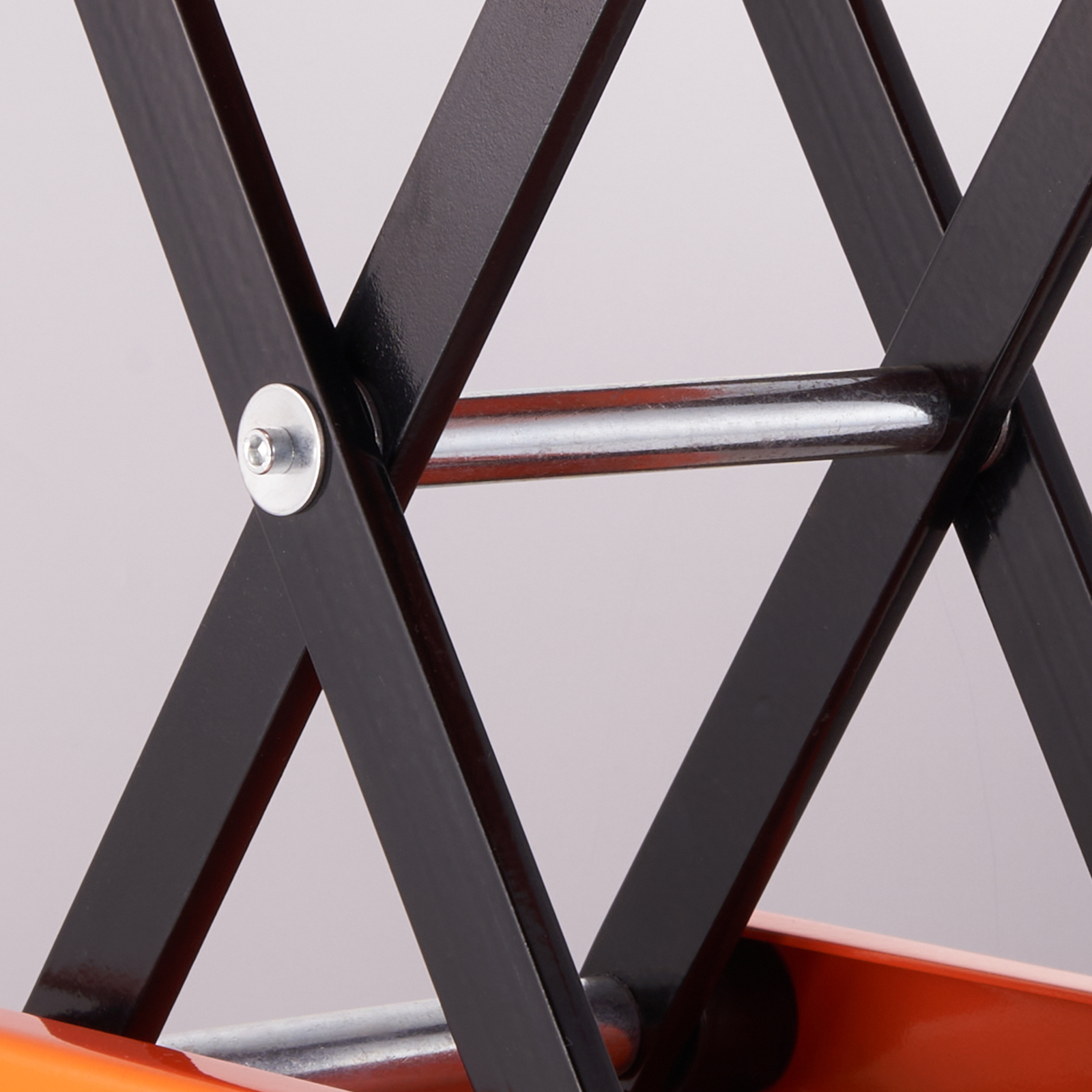 VEVOR motorcycle lift close-up showing black metal arms and an orange base.