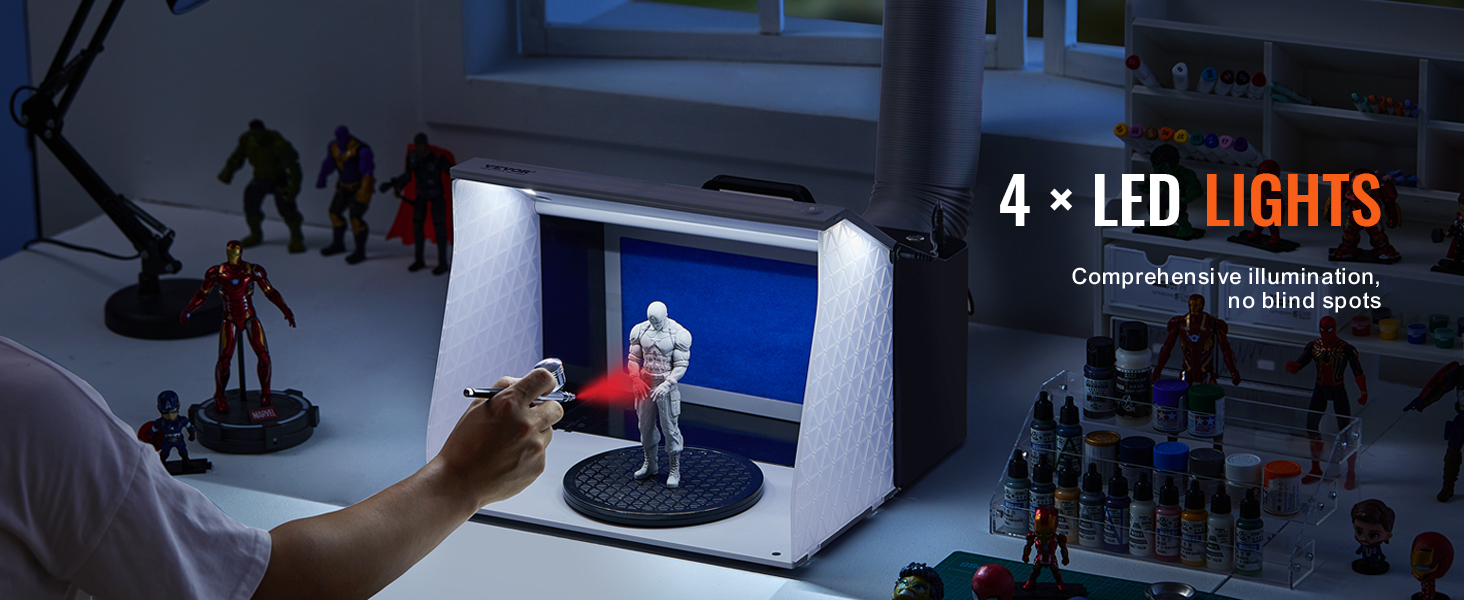 using VEVOR airbrush spray booth, painting a model in a well-lit booth with various figurines nearby.