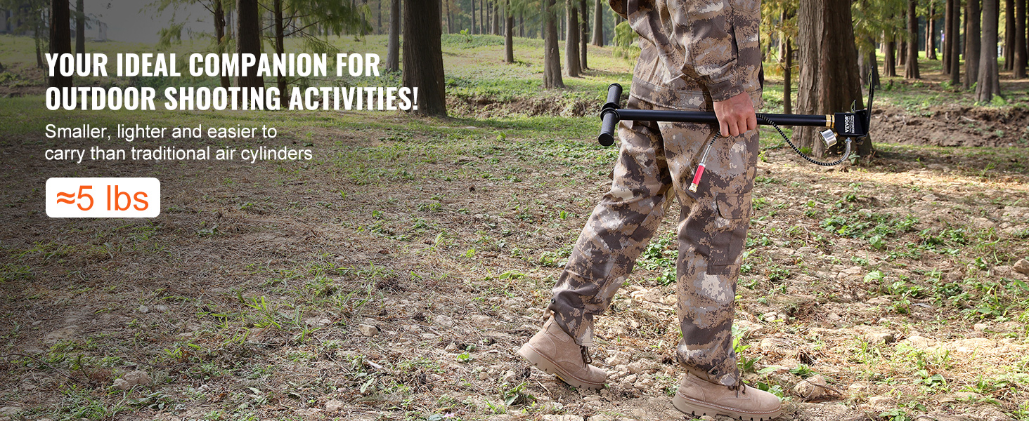 person carrying a VEVOR high pressure hand pump for outdoor shooting activities in wooded area.